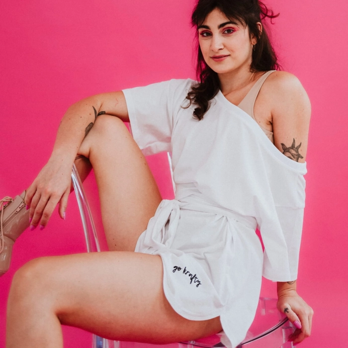 Biały oversize t-shirt Exo do pole dance – ujęcie siedzące z profilu